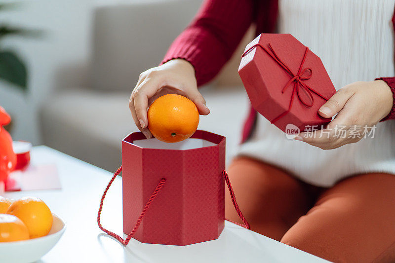 Asian Woman holding mandarin oranges with red gift box thankful present Lunar New Year. Chinese traditional holiday. Lunar new year culture.